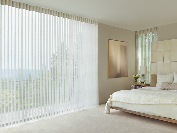 A bedroom with large windows featuring Luminette® Privacy Sheers; Fabric: Terra  Color: White Rice